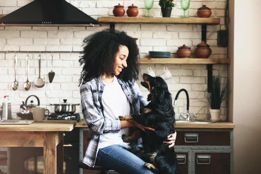 Woman with dog in kitchen