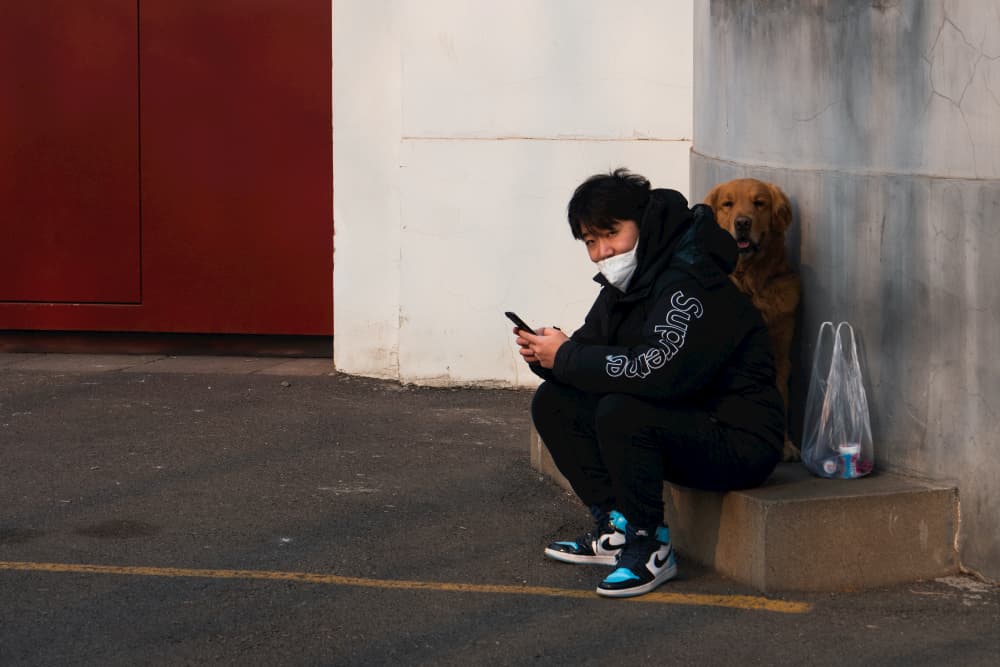 Man sits with dog in Beijing