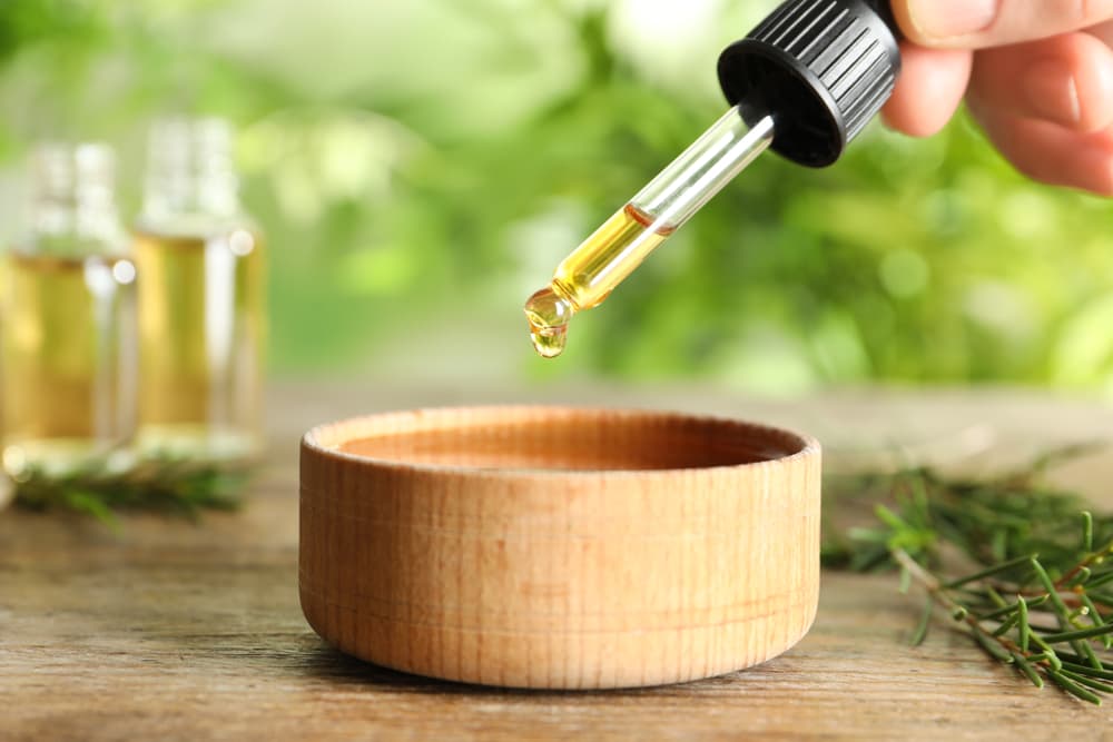 Dropper of tea tree oil in bowl
