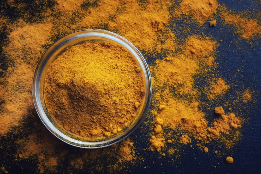Turmeric powder in a bowl on the table