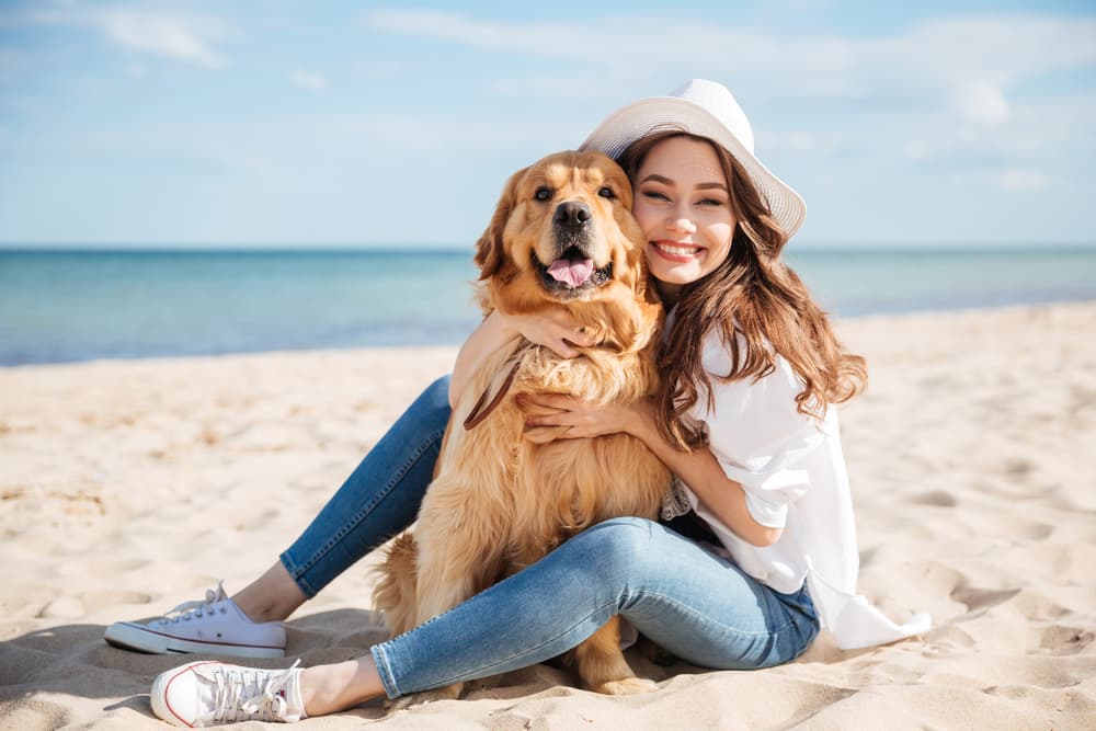 Woman sitting on the beach with her dog