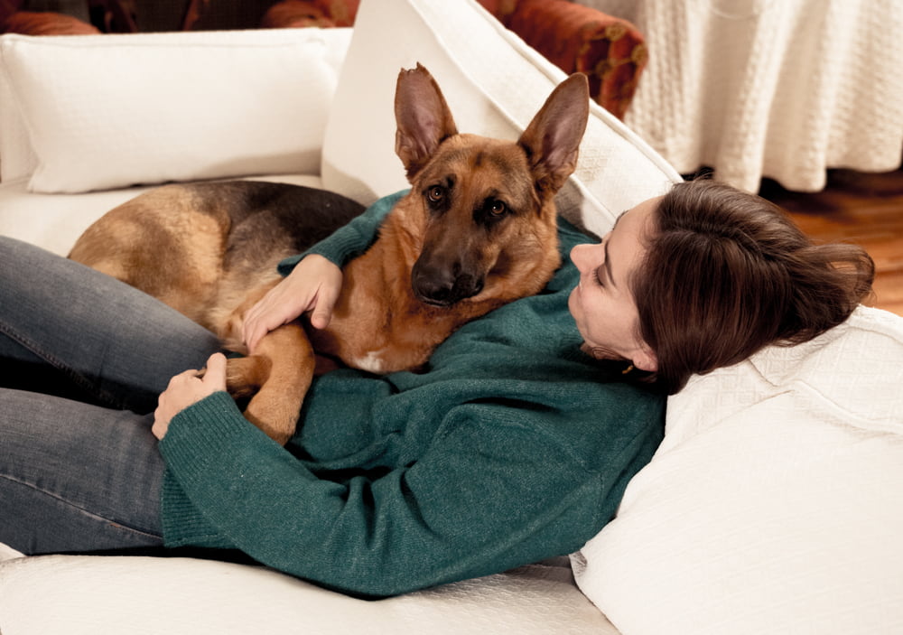 Woman cuddling with German Shepherd