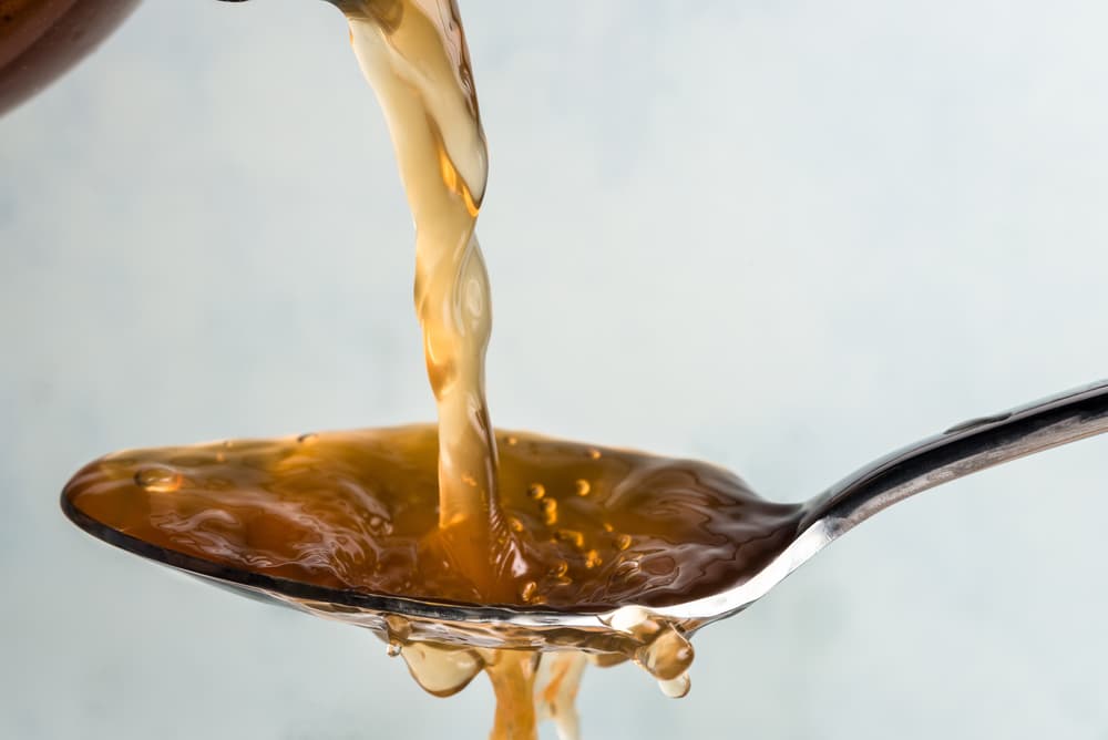 Apple cider vinegar for dogs pouring on spoon