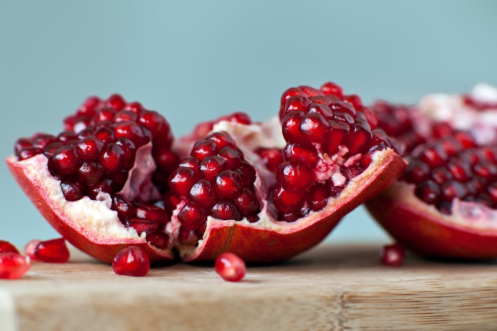 Fresh pomegranate sitting open on a table