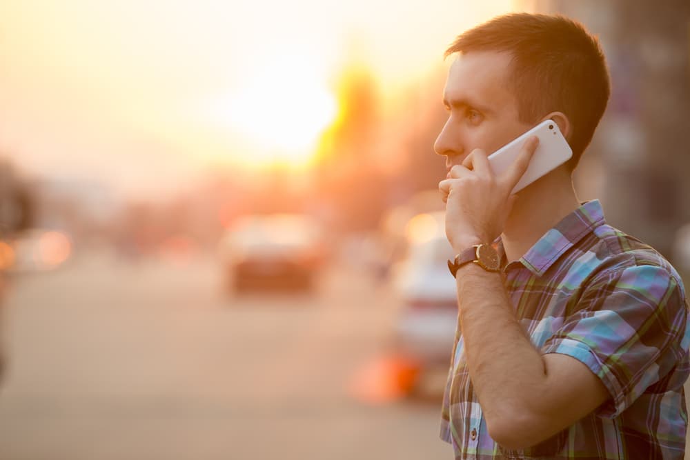 Man talking on phone on a busy street
