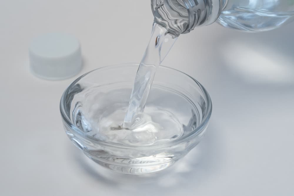 Bottle of vinegar being poured into small bowl, what smells do cats hate