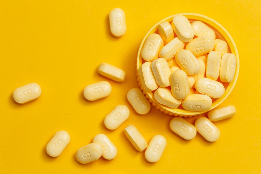 Vitamin B tablets sitting on the table in a pill bottle cap for dog vitamins