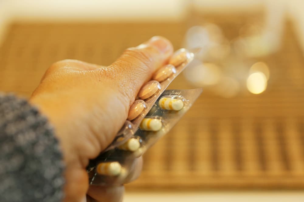 Person holding antibiotic courses of pills
