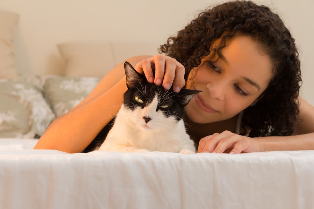 Woman with her cat on the bed