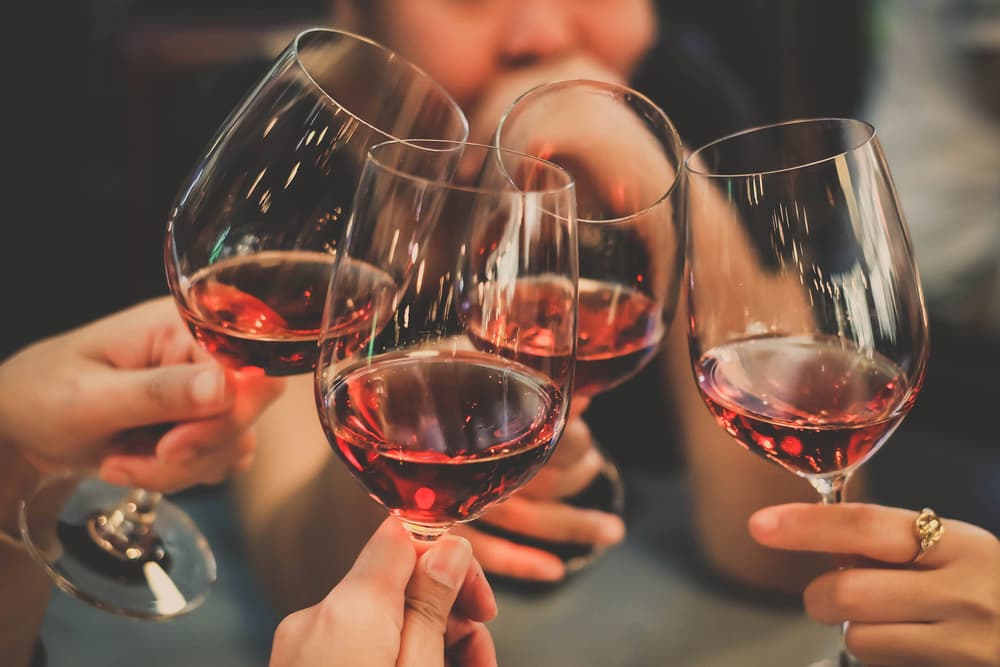 Clinking glasses of wine at party