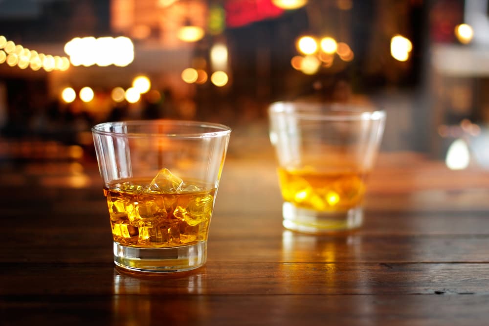 Glass of whiskey on table