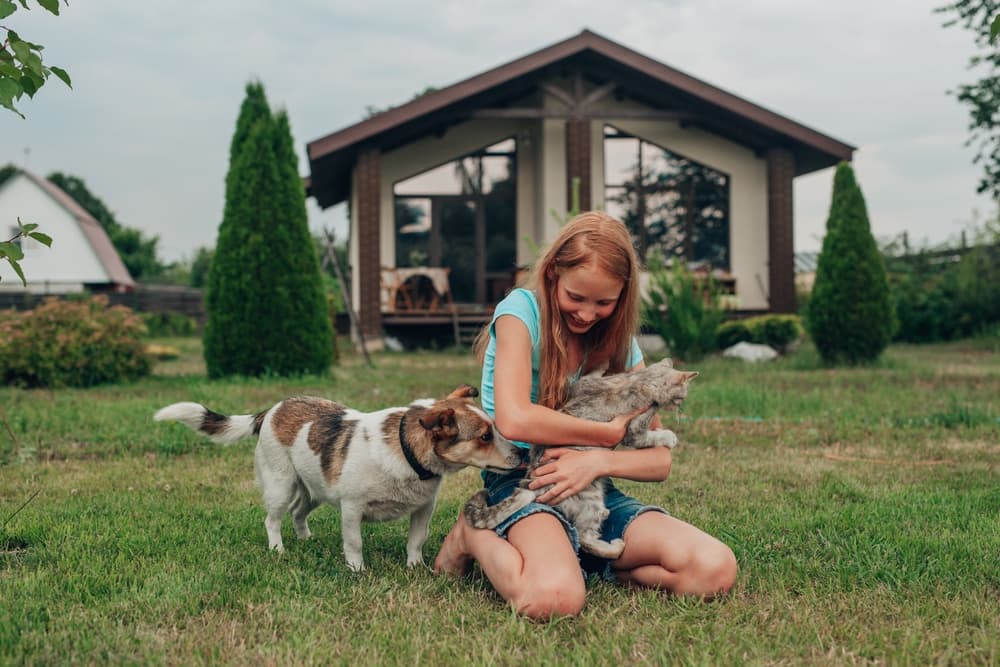 Pet parent with dog and cat outside