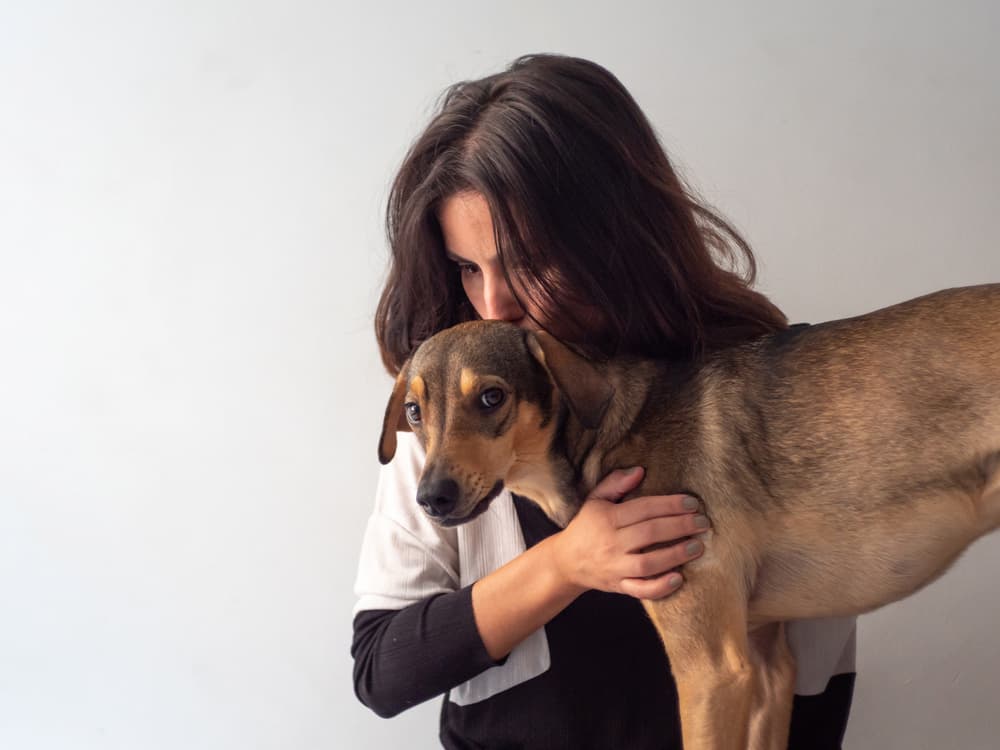 Sad woman pets her dog
