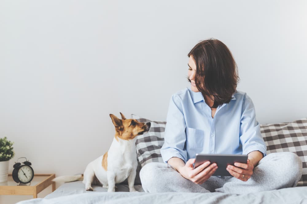Happy owner and dog sitting together listening to music